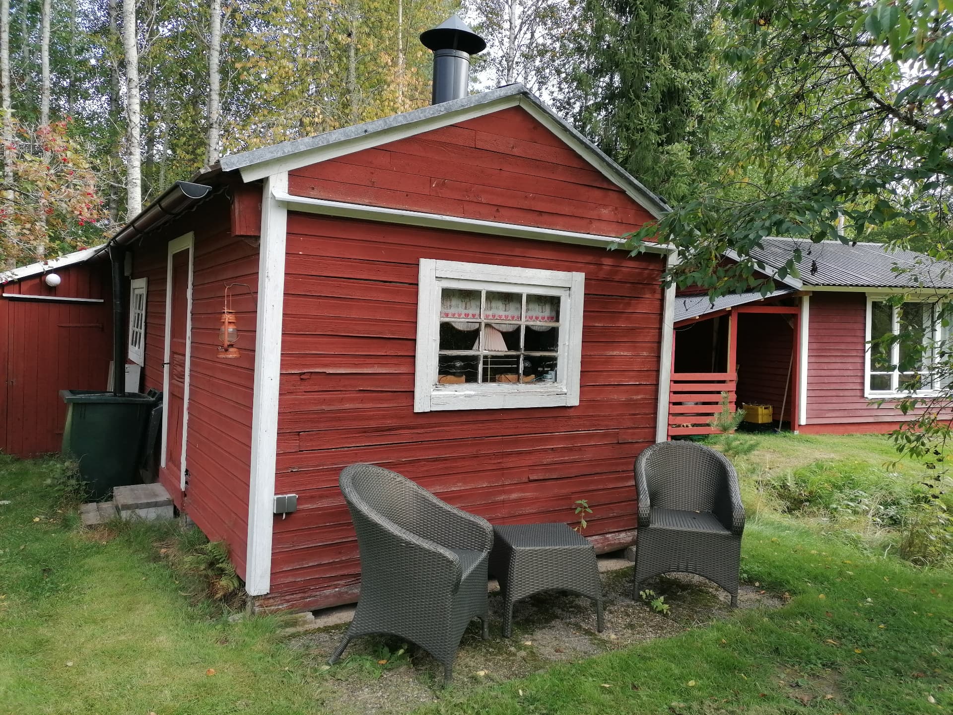 Grillstugan i trädgården med sittgrupp framför