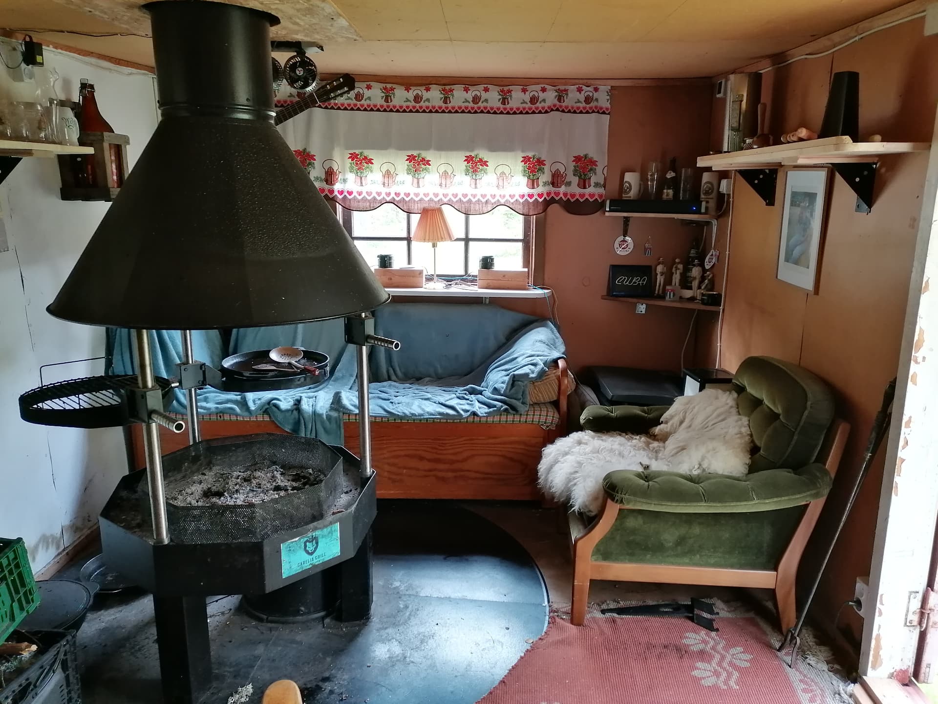 Insidan av grillstugan med öppen eld och grill i mitten