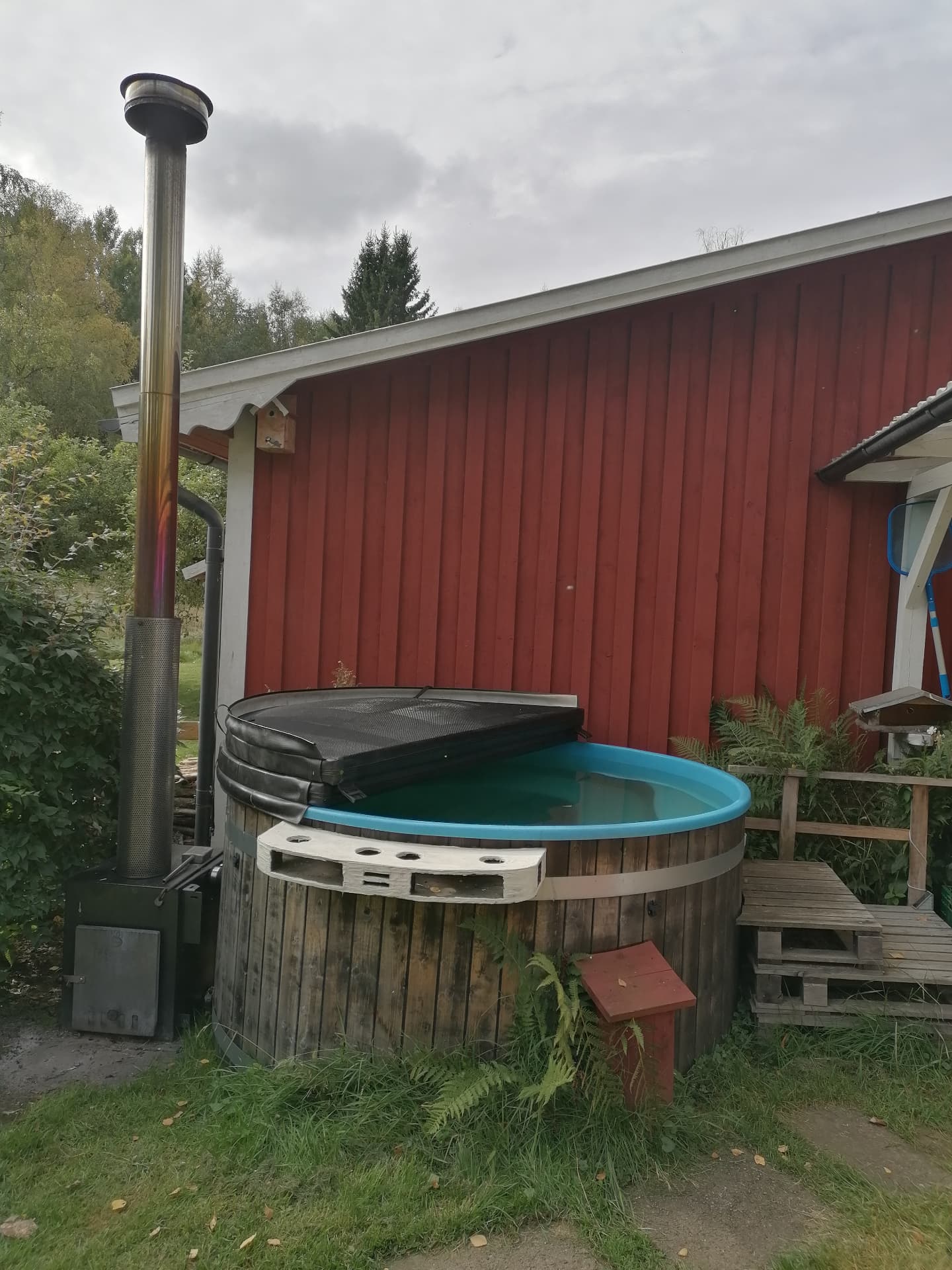 Badtunna i trä med vedeldad kamin vid huvudhuset