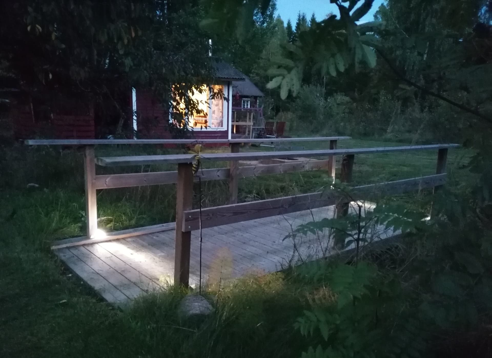 Liten träbro i trädgården på kvällen
