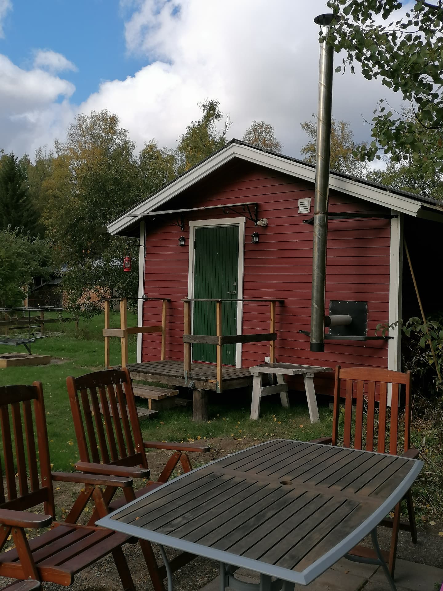Stugan sett från verandan med bord och stolar framför